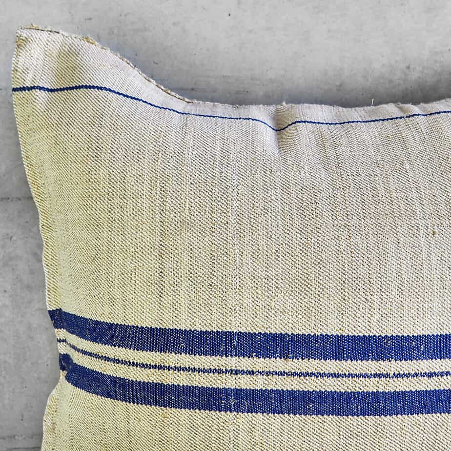 Cojín azul de lino natural confeccionado artesanalmente con sacos antiguos de harina.