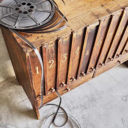 Cómoda antigua de sala de cinema de principios de siglo XX  de madera maciza con 12 cajones rectangulares y dos cajones inferiores (c.1920) .