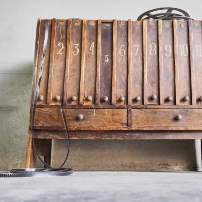 Cómoda antigua de sala de cinema de principios de siglo XX  de madera maciza con 12 cajones rectangulares y dos cajones inferiores (c.1920) .